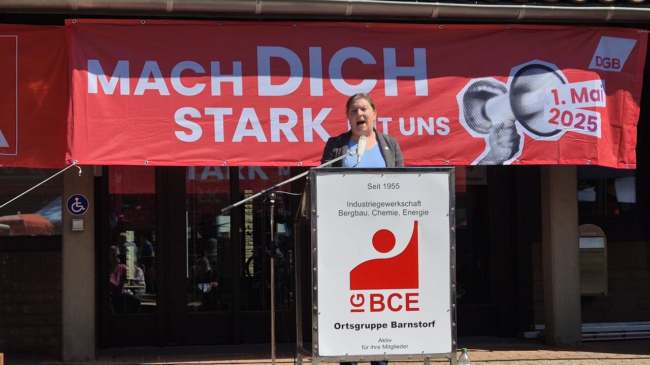 1_Mai_2025_Claudia_Tiedge Claudia Tiedge steht an einem Rednerpult und hält eine Rede.