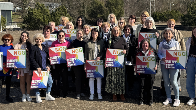 Eine Gruppe Frauen hält das Logo der NGG mit dem Slogan "Bunt statt braun" in die Kamera. 