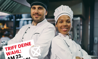 Ein Koch und eine Köchin lächeln in die Kamera.