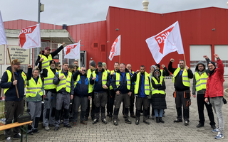 Eine Gruppe Streikender in neongelben Westen.