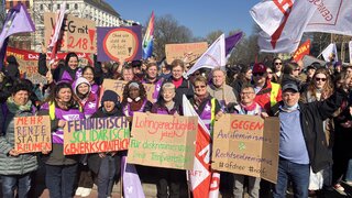 Ein Gruppenbild von Frauen beim 8. März mit Schildern. 