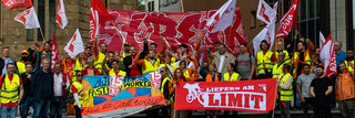 Gruppenbild mit vielen Lieferando-Lieferfahrer und -Lieferfahrerinnen bei einer Demonstration.