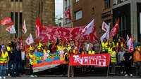 Gruppenbild mit vielen Lieferando-Lieferfahrer und -Lieferfahrerinnen bei einer Demonstration.