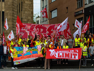 Gruppenbild mit vielen Lieferando-Lieferfahrer und -Lieferfahrerinnen bei einer Demonstration.