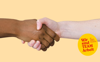 Zwei Menschen, einer mit hellere und einer mit dunklerer Haut, reichen sich die Hand.
