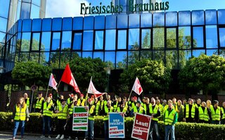 Streikende stehen vor dem Friesischen Brauhaus zu Jever. 
