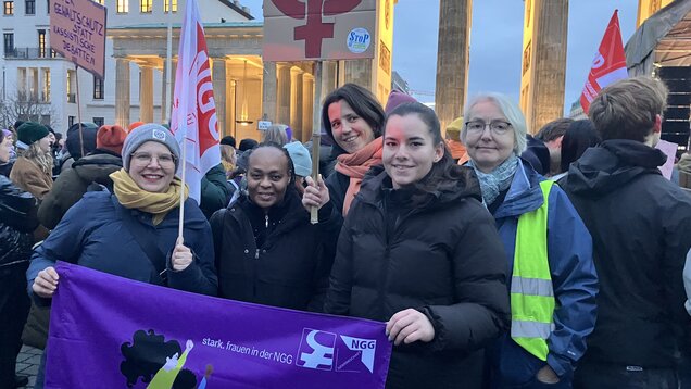 Eine Gruppe Frauen steht mit einer NGG-Frauen Fahne vor dem Brandenburger Tor